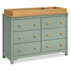 a green dresser with wooden drawers and knobs on the top, in front of a white background