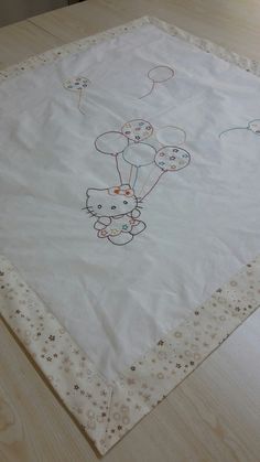 a white table cloth with an image of a teddy bear holding balloons in the sky