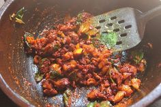 a skillet filled with cooked food on top of a wooden stove burner and spatula