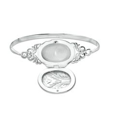 Delight her with this romantic vintage-inspired locket bangle. Fashioned in sterling silver, this beautiful look showcases an oval-shaped locket adorned with an intricate etched design. Sculpted filigree details flank the center. A sentimental touch, this style opens to reveal space for two small photos or other mementos. Buffed to a brilliant luster, this bracelet measures 7.0 inches in circumference and slips on and off for easy wear. Heirloom Oval Engraved Bracelets, Engraved Oval Bracelets For Wedding, Victorian Oval Engraved Bracelets, Ornate Oval Engraved Bracelets, Silver Engraved Bracelet For Memorial, Silver Engraved Bracelet For Memorials, Engraved Oval Bracelets, Engraved Silver Bracelet For Memorial, Memorial Engraved Silver Bracelets