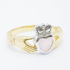 The perfect gift for yourself or someone close. Sterling silver claddagh ring set with milky pink heart shaped stone framed with white cubic zirconia in the cuffs. The hands represent friendship, the heart love and the crown stands for loyalty. This ring has been coated in a durable layer of 18k yellow gold, to maintain the color as long as possible please avoid contact with chemicals, lotions etc and keep in an airtight zip lock bag when not being worn. ----------------------------------------- Promise Jewelry With Heart Cut And Polished Finish, Polished Heart Cut Promise Jewelry, Heart Cut Polished Jewelry For Promise, Heart Cut Jewelry With Polished Finish For Promise, Heart Cut Promise Jewelry With Polished Finish, Classic Pink Jewelry For Promise, Pink Rings With Polished Finish For Gift, Pink Hallmarked Jewelry For Anniversary, Pink Promise Jewelry With Birthstone