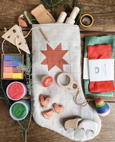 the contents of a christmas stocking laid out on a wooden table with scissors and other craft supplies