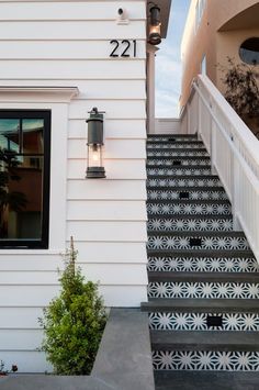 the steps lead up to an apartment building with decorative tiles on it's side