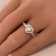 a woman's hand with a diamond ring on top of her finger and an engagement band