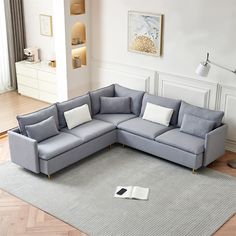 a grey sectional couch sitting on top of a gray rug