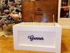 a wooden box sitting on top of a hard wood floor next to a christmas tree