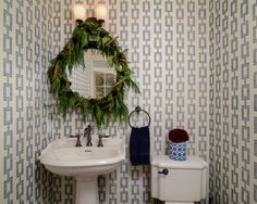 a bathroom with a wreath on the wall next to a toilet and sink in it