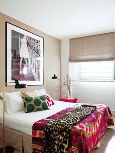 a bedroom with a bed and pictures on the wall above it, along with other decor items