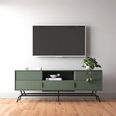 an entertainment center with a flat screen tv mounted on it's wall, next to a potted plant