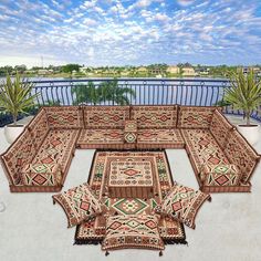 an outdoor area with rugs and potted plants on the balcony overlooking the water