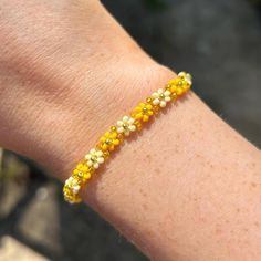 The perfect summer accessory - this cute yellow and gold flower beaded bracelet. You can even size up to style as an anklet! the perfect gift or treat for yourself. Explore more beaded bracelets and accessories at Dainty and Shine ✨  Size and details: Measuring 16cm with a 4.5cm extender chain, it offers a perfect fit for any wrist.  11/0 seed beads, and gold plated stainless steel clasp. Care instructions:  To keep it looking its best, gently wipe the bracelet with a soft cloth after wear to remove any oils or dirt. Avoid exposing it to water, perfumes, or lotions to maintain its delicate beauty over time. Gold Bracelets With Gold Beads For Summer, Handmade Gold Bracelets For Spring, Summer Friendship Gold Bracelets, Friendship Bracelet With Gold Beads, Gold Friendship Bracelets For Summer Festivals, Gold Bracelets For Friendship And Summer, Gold Bracelets For Friendship In Summer, Summer Gold Friendship Bracelets With Colorful Beads, Yellow Bracelets With Tiny Beads For Friendship