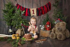 a baby boy sitting in front of christmas decorations