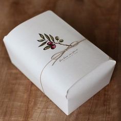 an open box on a wooden table with a ribbon tied around the inside of it