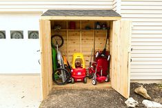 a wooden shed with several different types of toys in it and the doors open to reveal a garage