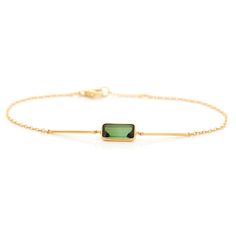 Tourmaline is known to occur in nature with excellent vibrancy of color and this bracelet is an excellent example.  Two gold bars flank the central green gem to emphasize its beauty. This is a handmade treasure.  This unique design is perfect for the modern woman. A modern classic that can be worn everyday.  Hand forge Elegant Gold Tourmaline Bracelets, Modern Green Gemstone Bracelets, Modern Yellow Gold Tourmaline Jewelry, Modern Gold Tourmaline Jewelry, Modern Green Tourmaline Jewelry, Elegant Tourmaline Bracelets As Gift, Elegant Tourmaline Bracelets For Gift, Elegant Tourmaline Bracelet For Gift, Elegant Green Gemstone Gold Bracelet