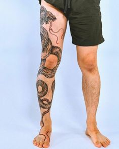 a man's legs with tattoos on them and his leg in the shape of a snake