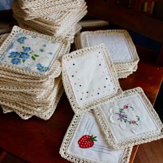 several pieces of crocheted cloth with flowers and berries on them sitting on a table