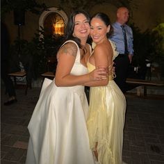 two women hugging each other at a formal event