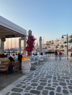 people are sitting at tables near the water