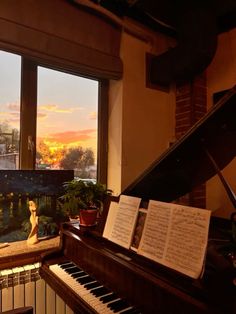 a piano sitting in front of a window next to a piano and music sheets on the floor