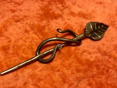 a pair of scissors sitting on top of a brown table next to a red cloth