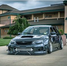 the front end of a gray subarunt car parked in front of a building