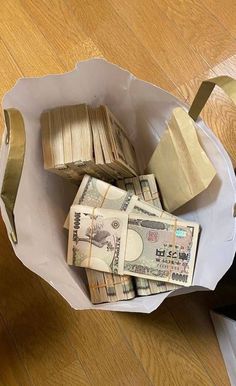 a bag filled with money sitting on top of a wooden floor