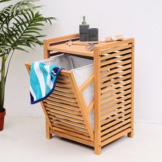 a wooden table with a towel and potted plant next to it on a white floor