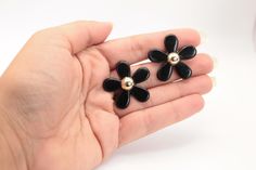 These earrings are a wonderful example of fun 80s earrings. They are huge and they feature a wonderful 5 petal daisy in black with a light gold domed center. These are in very good condition and look amazing. They are made of lucite/plastic, with a medium size gold clip on. They are very light. They measure 3.3cm (1 1/3") across.  They are absolutely fantastic. You will love them! To go back to Ethereal Emporium: http://www.etsy.com/shop/etherealemporium Thanks for looking at my listing. Please convo me for more pictures or information 80s Earrings, Gold Clips, Gold Flower, Gold Flowers, Black And Gold, Clip On, Clip On Earrings, Medium Size, Favorite Jewelry