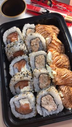 sushi and rolls in a plastic container on a table