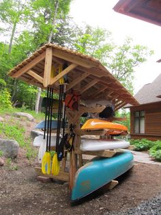 kayaks and paddles are lined up under a shelter