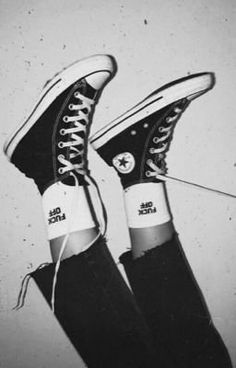 black and white photograph of someone's converse shoes