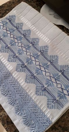 a blue and white table cloth sitting on top of a counter next to a computer