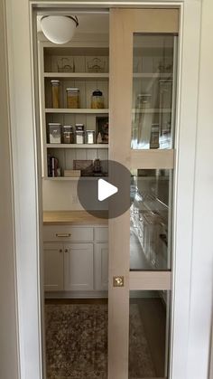 an open pantry door in a kitchen with white cabinets and cupboards on either side