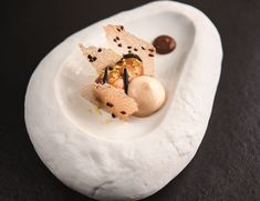 a white plate topped with food on top of a black tablecloth covered flooring