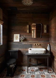 a bathroom with wood paneling and a white sink in it's center area