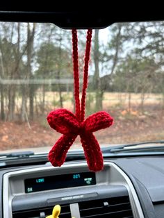 the interior of a car is decorated with red knitted bows and yellow rubber ducks