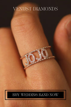 a woman's hand holding a diamond ring with the word love written on it