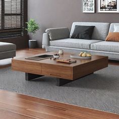 a living room with couches, coffee table and pictures on the wall above it