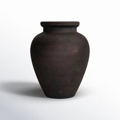 a black vase sitting on top of a white table