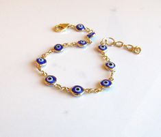 Blue and Gold Evil Eye Bracelet, Protection Bracelet, Trending Evil Eye Jewelry, Personalized Adjustable Bracelet in Blue, Friendship Gift ::THE DETAILS"" --Beautiful quality chain is made with 24kt gold heavily plated over brass. --Petite, blue, white and black evil eye connectors are double sided and rimmed in gold. --Evil eye connectors measure 6x13mm, including the loops.   --Bracelet chain is lightweight. --Bracelet closes with a 14kt gold filled lobster clasp. --Bracelet extender chain is Blue Adjustable Chain Bracelet, Bohemian Blue Charm Bracelet As A Gift, Bohemian Blue Charm Bracelet For Gifts, Bohemian Blue Charm Bracelet As Gift, Adjustable Blue Bohemian Chain Bracelet, Bohemian Blue Charm Bracelet Gift, Nickel-free Blue Charm Bracelet For Gift, Blue Nickel-free Charm Bracelet As Gift, Nickel-free Blue Charm Bracelet Gift