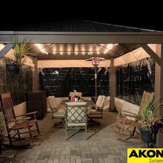 a covered patio with chairs, table and lights