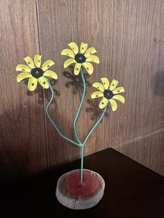 three yellow flowers are placed in a vase