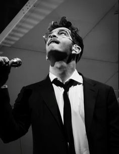 a man in a suit and tie singing into a microphone