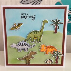 a card with dinosaurs and palm trees in the background, says have a roar - some day