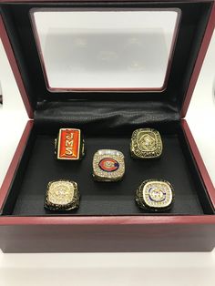 five rings in a wooden box on display