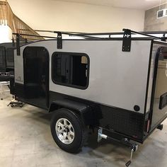 a small trailer is parked in a garage