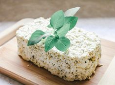 a square piece of cheese with green leaves on top