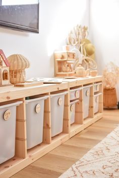 several storage bins are lined up on the floor in front of a white wall