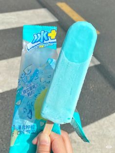 a person holding an ice cream on a stick